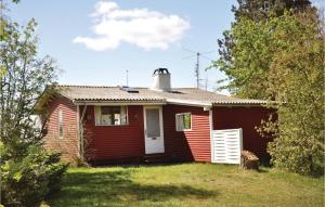 a small red house with a white door at Holiday Home Strandholmen Millinge V in Millinge