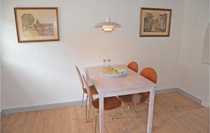 a dining room table with chairs and a bowl of fruit on it at Beautiful Home In Assens With Kitchen in Assens