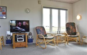 - un salon avec deux chaises et une télévision à écran plat dans l'établissement 3 Bedroom Cozy Home In Hvide Sande, à Havrvig