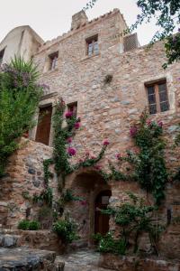 un viejo edificio de piedra con flores. en CASA FELICIA-The Castle Mansion en Monemvasía