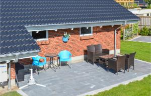 a patio with chairs and a table and a building at Three-Bedroom Holiday Home In Hadsund in Haslevgårde +14 photos