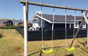a swing in front of a house at Holiday Home Hvide Sande 36 in Hvide Sande