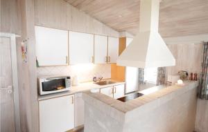 ヴィデ・サンデにあるAmazing Home In Hvide Sande With 3 Bedrooms And Wifiのキッチン(白いキャビネット、電子レンジ付)