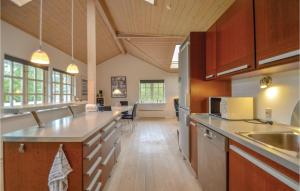 エーベルトフトにあるBeautiful Home In Ebeltoft With Wifiの大きなキッチン(木製キャビネット、カウンタートップ付)