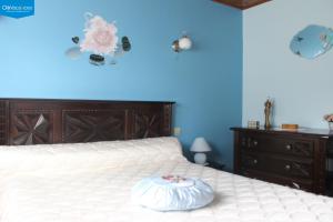 1 dormitorio con cama blanca y pared azul en Maithagarria, en Aicirits