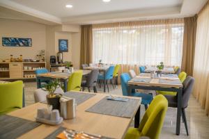 ein Restaurant mit Holztischen und -stühlen und einem Fenster in der Unterkunft Hotel Soni Lux in Tuzla