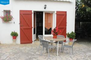 una mesa y sillas frente a una casa con puertas rojas en Maithagarria, en Aicirits