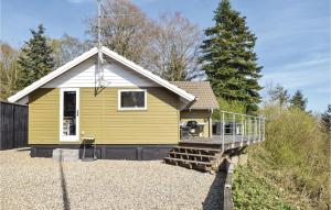 una casa amarilla con porche en un cementerio en Awesome Home In Silkeborg With House Sea View, en Silkeborg