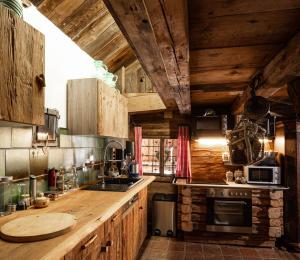 a kitchen with wooden cabinets and a counter with a sink at Romantische Hütte in Ramsau