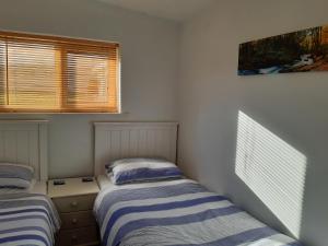 dos camas sentadas una al lado de la otra en una habitación en Chalet 18 Widemouth Bay Holiday Village, en Bude
