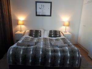 Un dormitorio con una cama grande con dos lámparas. en Siljo Apartments, en Rovaniemi