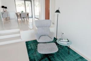 a living room with a chair and a table at Casa Reserva do Poeta in Viana do Castelo