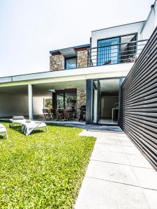 a house with a patio and a grass yard at Casa Reserva do Poeta in Viana do Castelo