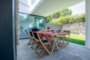 Une table à manger et des chaises sont disponibles sur la terrasse. dans l'établissement Casa Reserva do Poeta, à Viana do Castelo