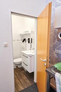 a bathroom with a toilet and a sink at Aparthotel Wilma in Bremen
