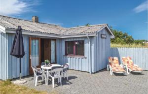 a patio with a table and chairs and an umbrella at Holiday Home Arvidvej Denmk Xii in Bjerregård