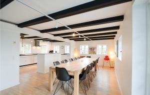 エーベルトフトにあるCozy Home In Ebeltoft With Kitchenの大きなダイニングルーム(長いテーブルと椅子付)