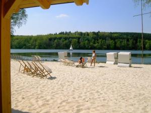 a couple of people sitting in chairs on a beach at --- SEEDOMIZIL --- moderne Ferienwohnung mit Terrasse in Möhnesee