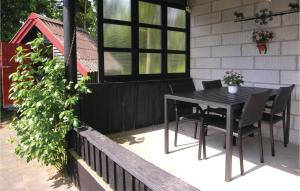 a patio with a table and chairs on a house at Hytten in Magleby