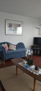 a living room with a blue couch and a coffee table at Departamento frente al mar 4 personas, La Serena in La Serena
