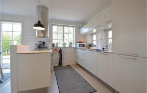 エーベルトフトにあるAwesome Home In Ebeltoft With 2 Bedrooms And Wifiのキッチン(白いカウンター、白いキャビネット、窓付)