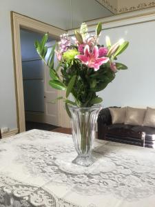 un jarrón lleno de flores sentado en una mesa en Angaston Masonic Lodge en Angaston