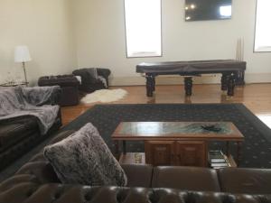 a living room with a couch and a piano at Angaston Masonic Lodge in Angaston