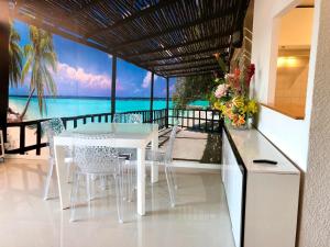 una sala da pranzo con tavolo e sedie e l'oceano di BARCARESA-Appartement belle vue mer piscine tennis mini golf wifi a Le Barcarès