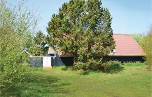 ein Haus mit einem Zaun und einem Baum im Hof in der Unterkunft Amazing Home In Fan With Wifi in Sønderho