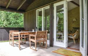 a screened in porch with a table and chairs at 2 Bedroom Stunning Home In Frederiksvrk in Liseleje