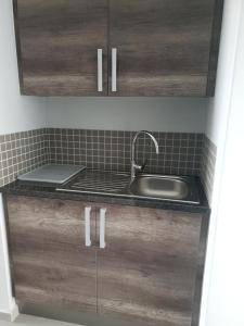 una cocina con armarios de madera y fregadero en Bayview Suites, Unit 9, Room # 13, en Langstrand