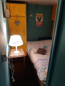 a small bedroom with a bed and a lamp on a table at Boshuis Turquoise / smaakvol genieten op de Veluwe in Hoenderloo +83 photos