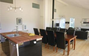 a kitchen and dining room with a table and chairs at Holiday Home Sahara Rønne I in Hasle
