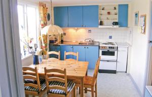 SöderåkraにあるAmazing Home In Torss With Kitchenのキッチン(木製テーブル、青いキャビネット付)