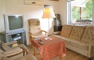 a living room with a couch and a tv at Two-Bedroom Holiday Home In Tarm in Hoven