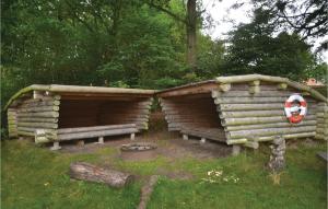 two wooden huts with a fire pit in the grass at Two-Bedroom Holiday Home In Tarm in Hoven