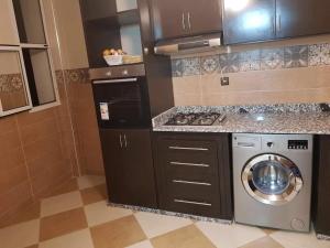 a kitchen with a washer and a washing machine at Appartement Wynwood 2 in Oujda