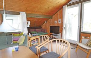 Bjerregårdにある3 Bedroom Cozy Home In Hvide Sandeのリビングルーム(テーブル、椅子、テレビ付)