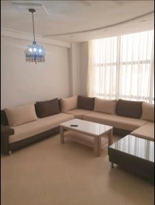 ein Wohnzimmer mit einem Sofa und einem Couchtisch in der Unterkunft Appartement Wynwood 2 in Oujda
