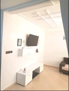 ein Wohnzimmer mit einem TV an einer weißen Wand in der Unterkunft Appartement Wynwood 2 in Oujda