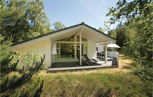 a small white cottage with a large glass door at Hubertus in Spidsegård