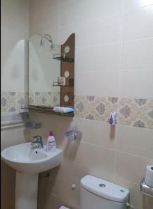 ein Badezimmer mit einem Waschbecken, einem WC und einem Spiegel in der Unterkunft Appartement Wynwood 2 in Oujda