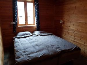 Cama en habitación de madera con ventana en Vikaneset Havhotell en Kristiansund