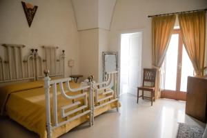 1 dormitorio con 1 cama, 1 silla y ventanas en Corte Baldi, en Galatina