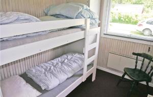 two bunk beds in a room with a chair and a window at Amazing Home In Glesborg With 3 Bedrooms And Wifi in Glesborg