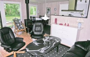 a living room with black leather chairs and a table at Holiday Home Bygtoften Glesborg Vi in Glesborg