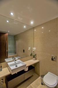 uma casa de banho com um lavatório, um WC e um espelho. em Afurada premium apartment by Porto City Hosts em Vila Nova de Gaia