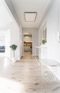 Il comprend une cuisine et un salon avec des murs blancs et du parquet. dans l'établissement Apart Market Square - Rynek 44 - Opposit Town Hall - 3 Rooms, à Wrocław