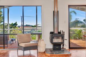 a living room with a wood stove and a couch at Zephyr Shores - Port Willunga - C21 SouthCoast Holidays in Port Willunga