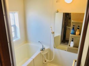 北谷町的住宿－Mini Chula Inn，带浴缸和镜子的浴室